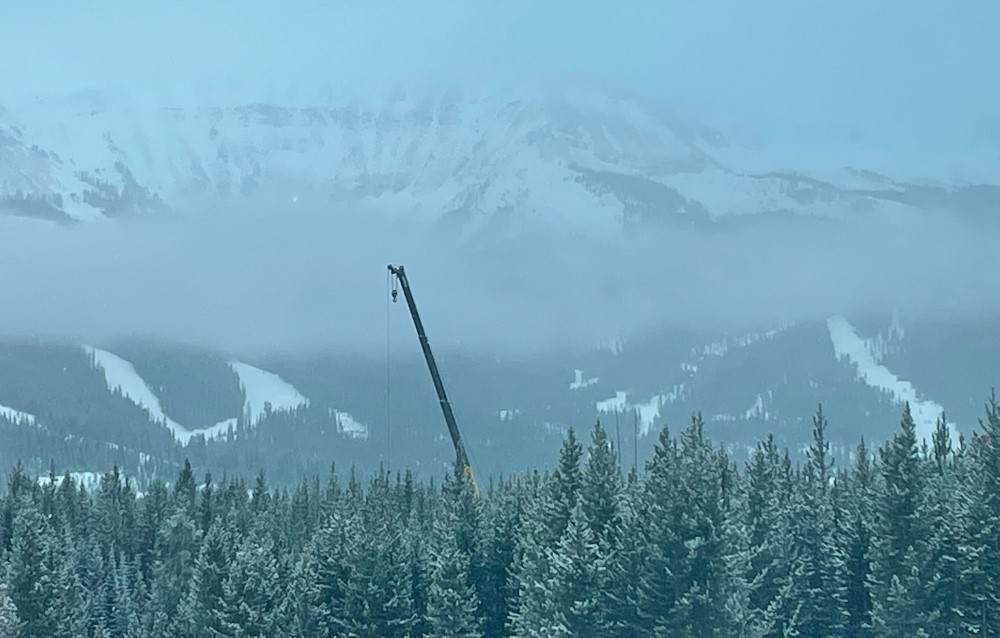 construction crane operating on new home in the mountains of montana